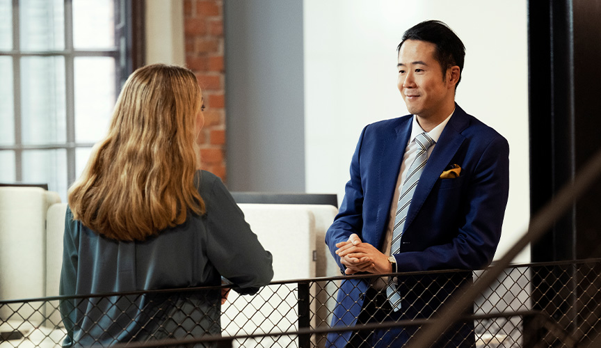 A man in a blue suit talking to a woman (photo)