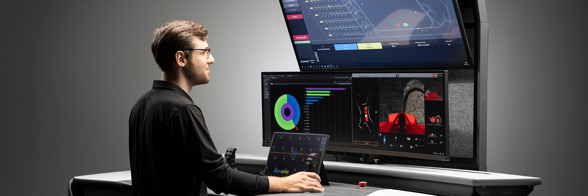 Man standing in a control room looking at screens with charts (photo)